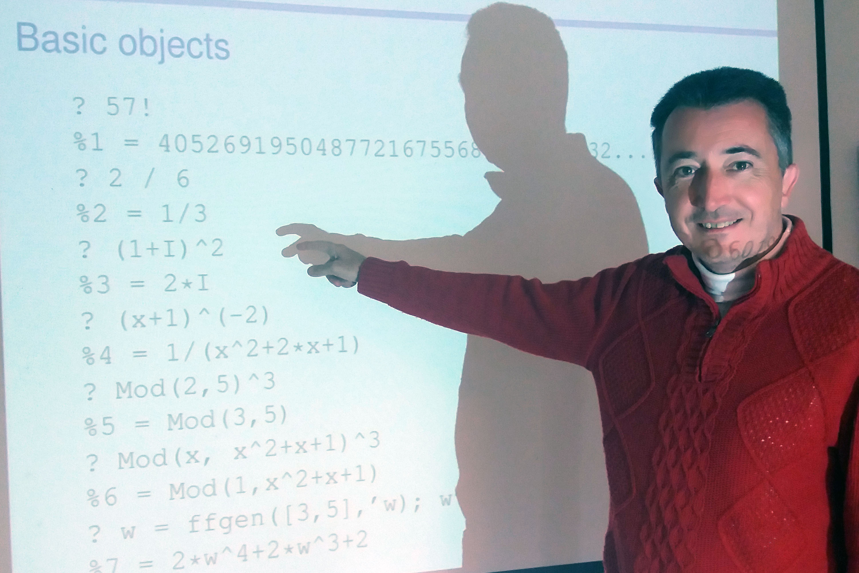 Bill Allombert devant un mur o&ugrave; sont projet&eacute;es quelques lignes de code Pari/GP