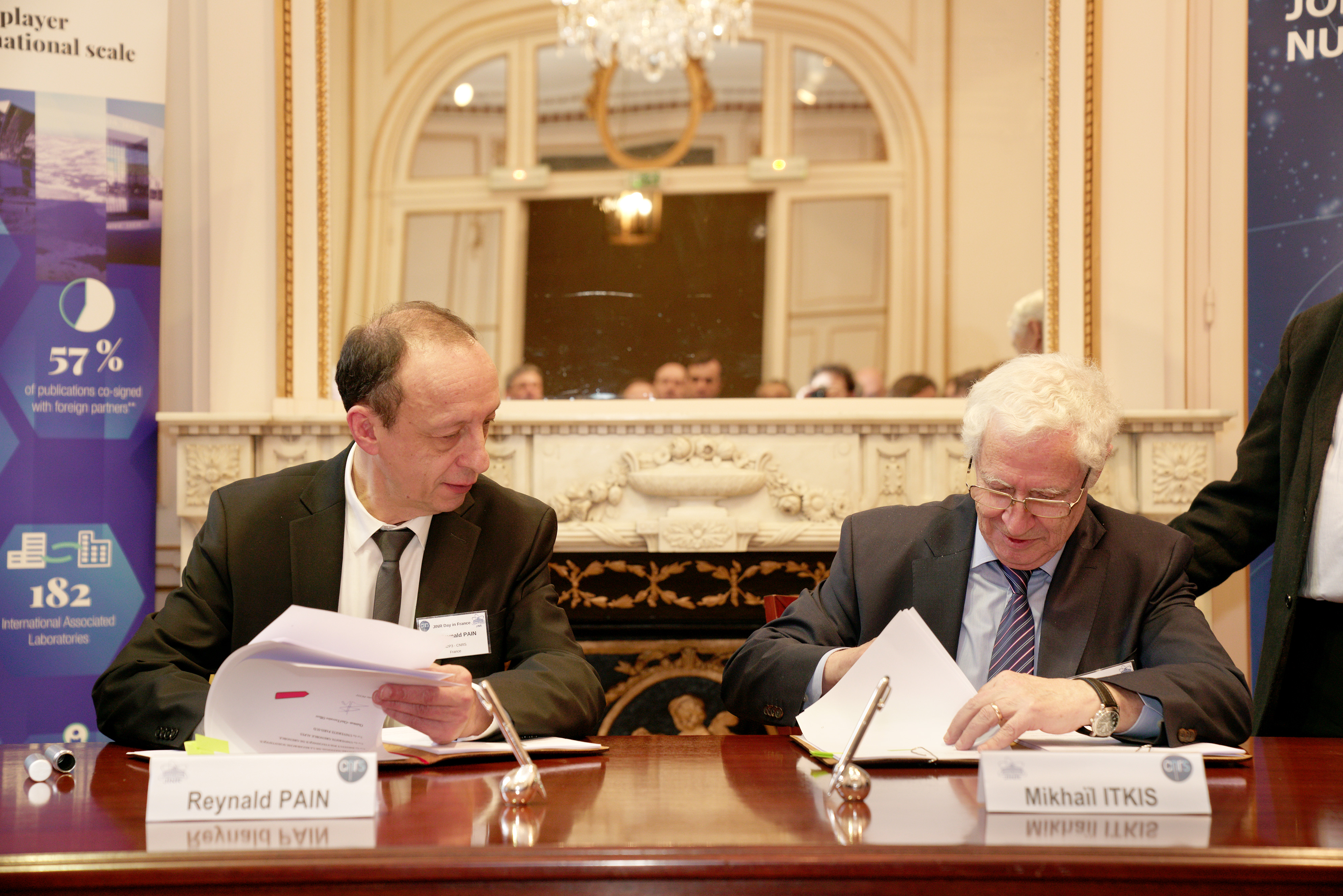 Reynald Pain et Mikhail Itkis assis &agrave; un bureau signe des documents.