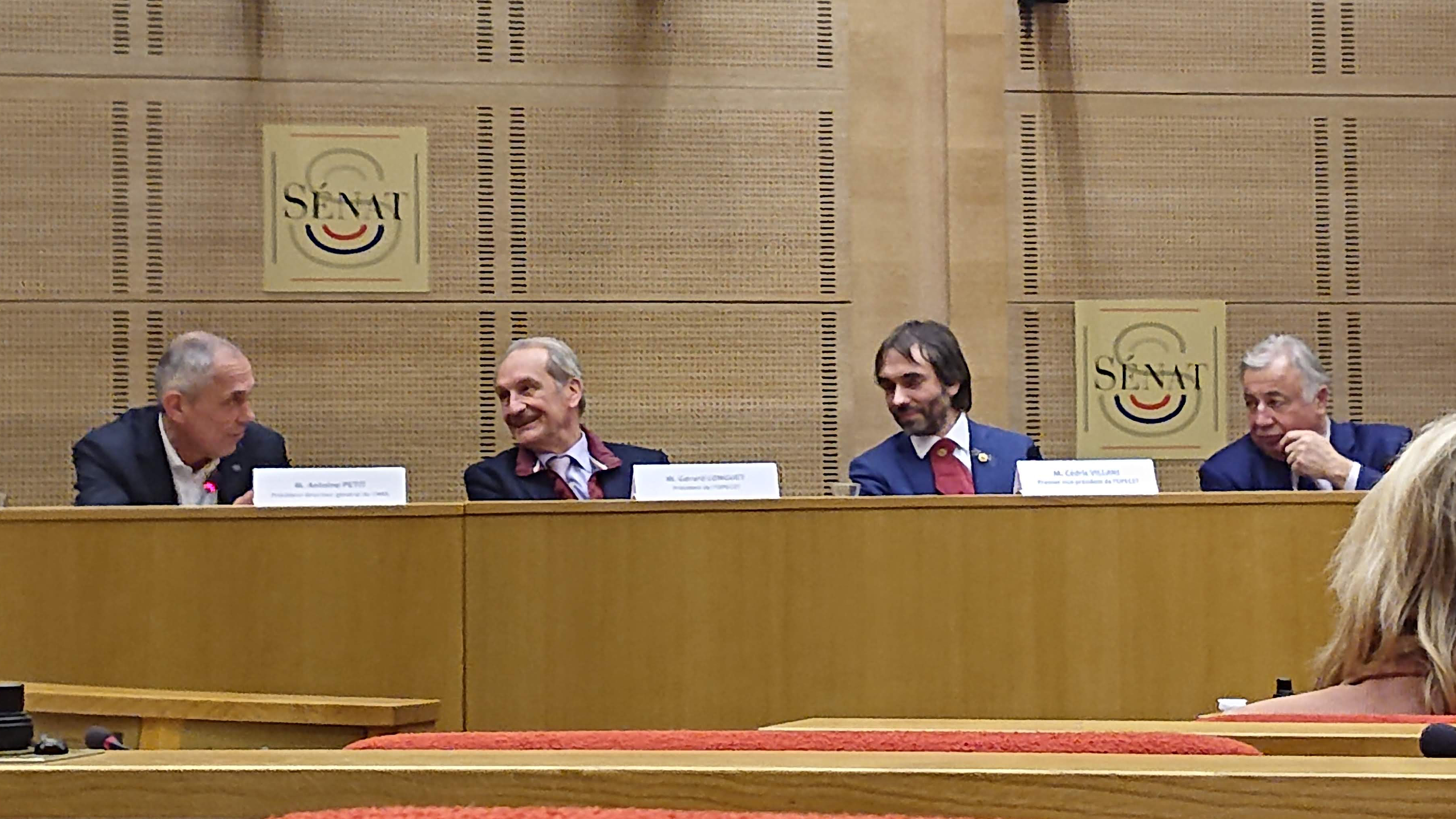 MM. Petit, Longuet, Villani et Larcher sur une estrade dans une salle du S&eacute;nat