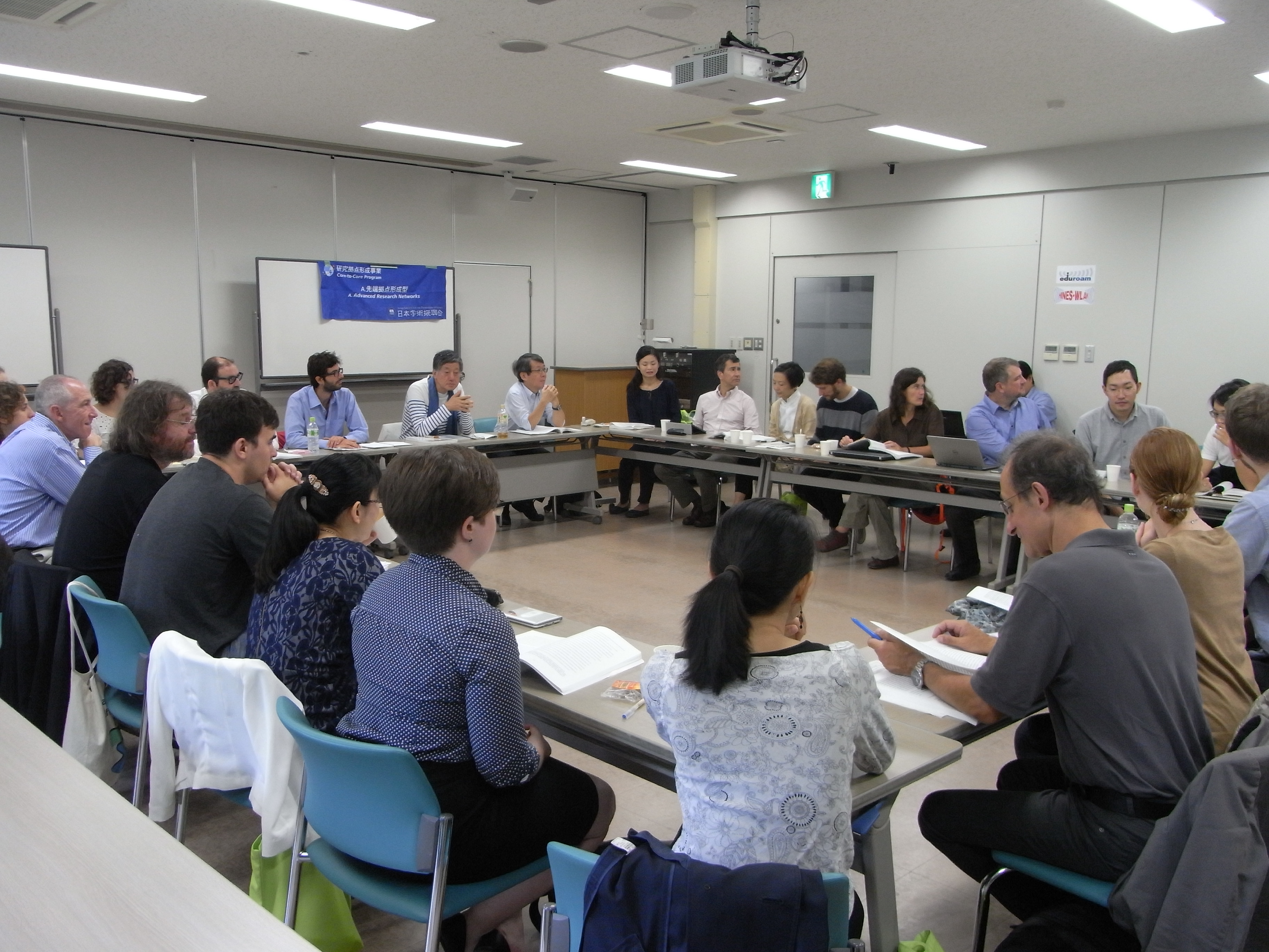 Groupe de Japonais, Fran&ccedil;ais, Am&eacute;ricains et Allemands autour de tables plac&eacute;es en carr&eacute;